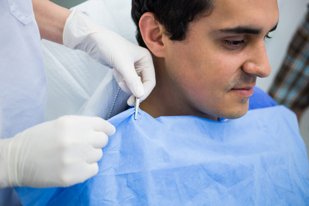 dentist assisting a patient to wear dental apron at clinic