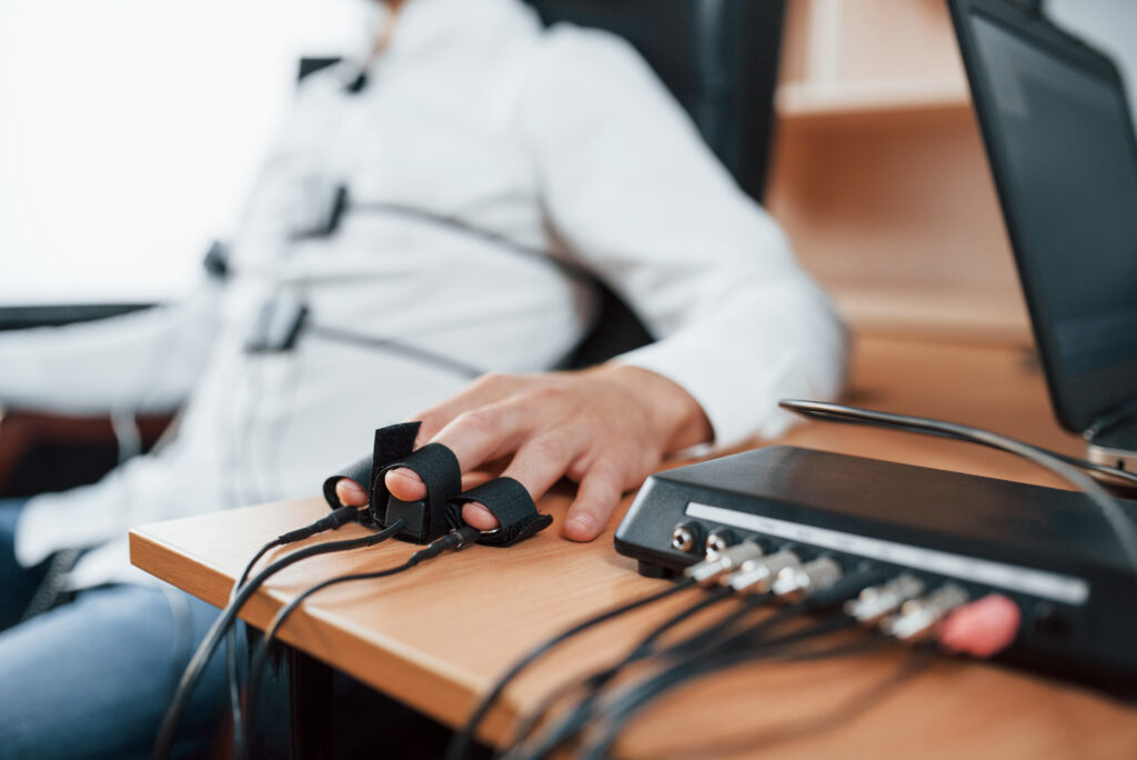 focused photo. suspicious man passes lie detector in the office. asking questions. polygraph test