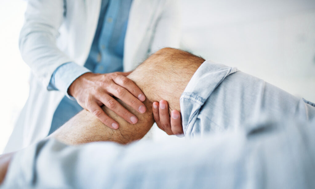 Doctor examining patient’s knee for injury