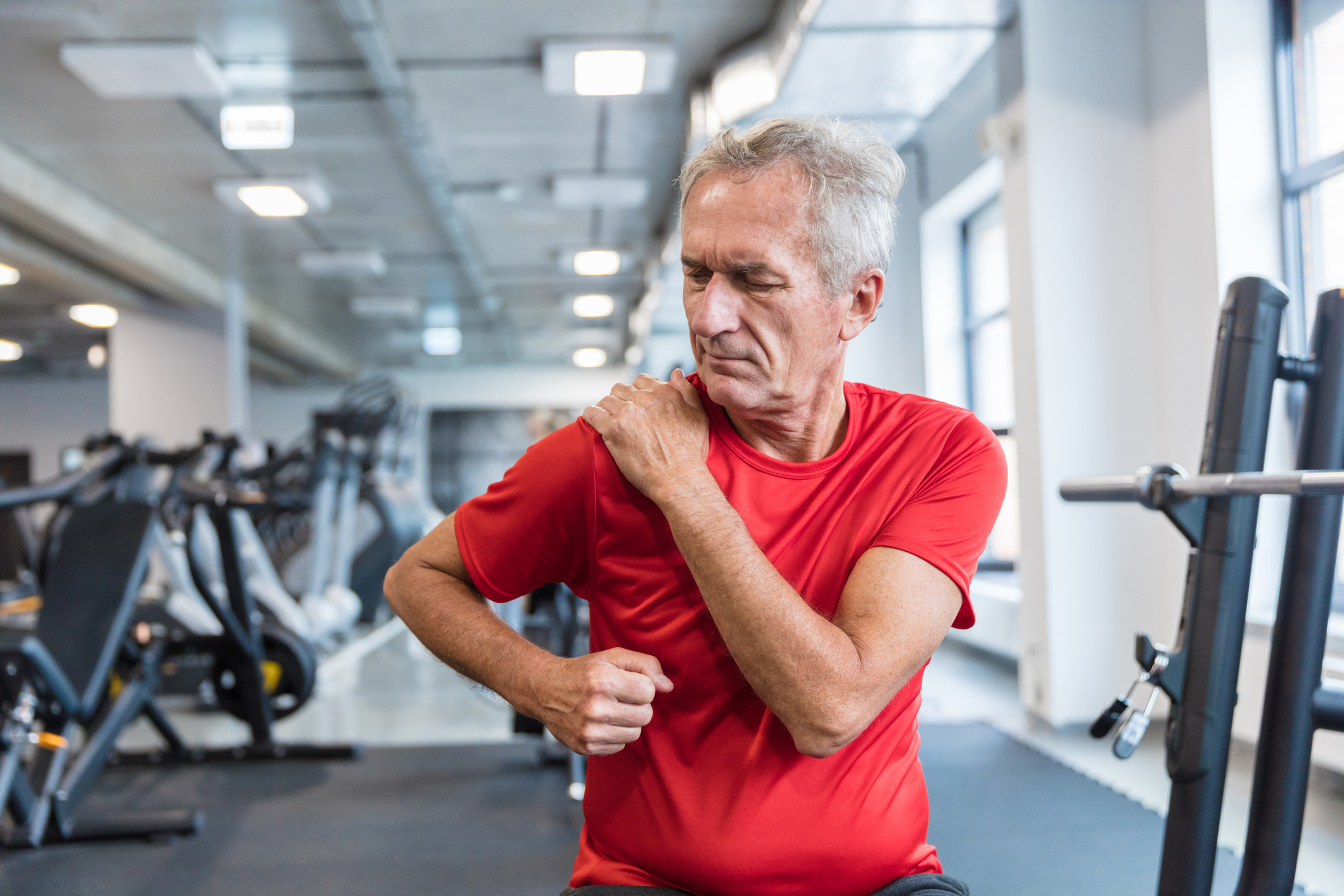 Person in gym grabbing shoulder in pain